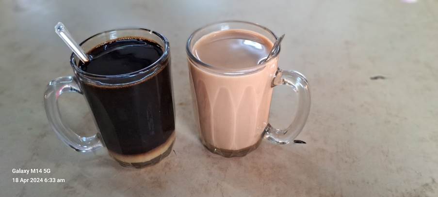 A glass mug with liquid in it next to a glass mug with a spoon

Description automatically generated